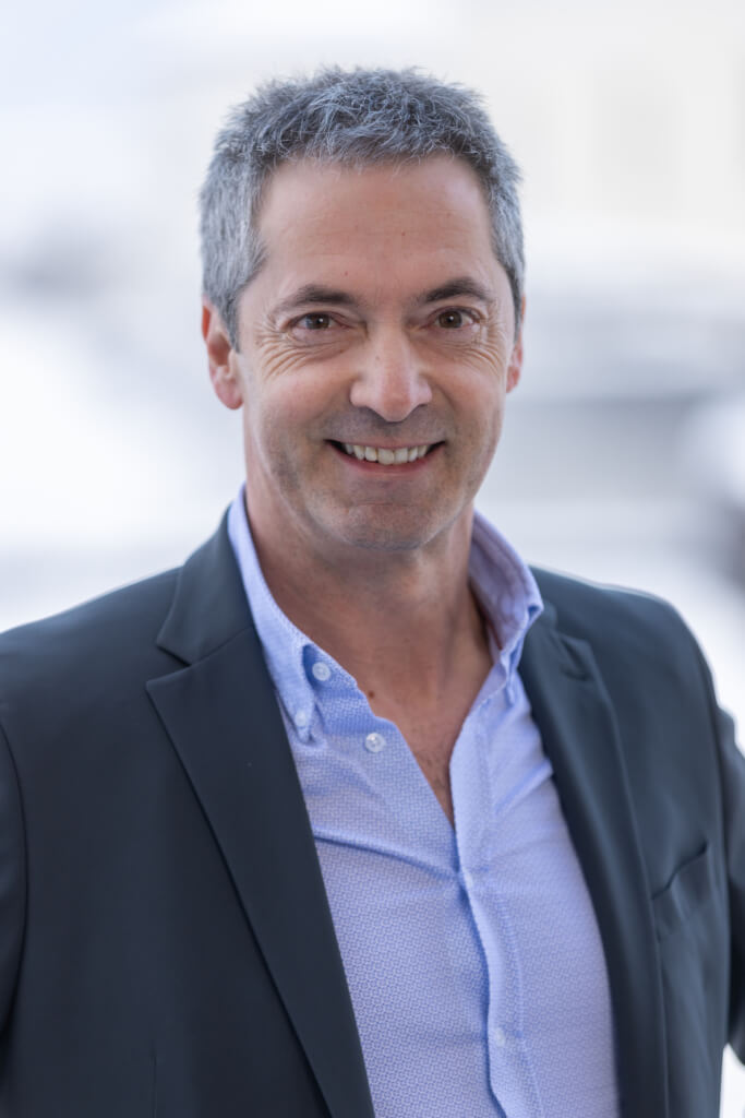 Mann mit grauen Haaren und Anzug lächelt, symbolisiert Bürgerengagement in Kaprun.